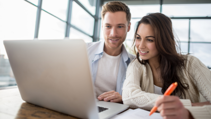 Happy couple reviewing financial documents at home, symbolising secure financial planning in Croydon.