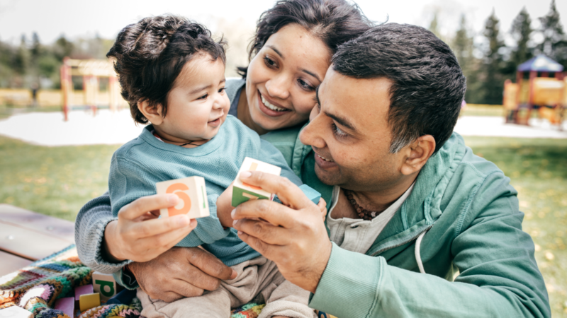 Young couple with their child at home, representing family security with mortgage protection insurance