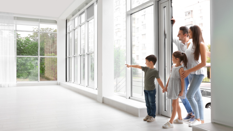 Family standing in front of their home, symbolising peace of mind provided by mortgage life insurance