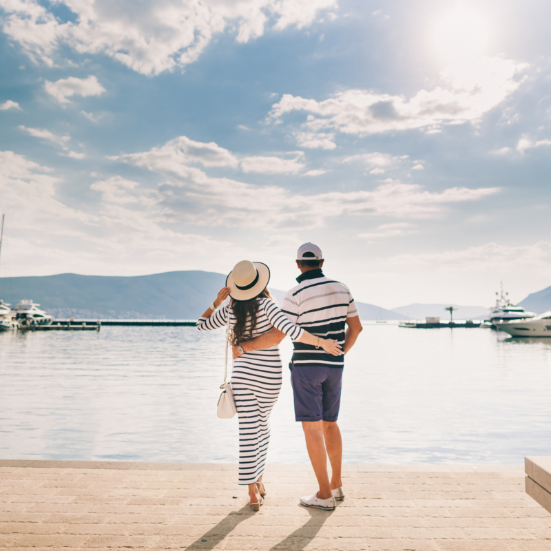 Couple walking hand in hand along the beach at sunset, symbolising financial freedom and a secure future